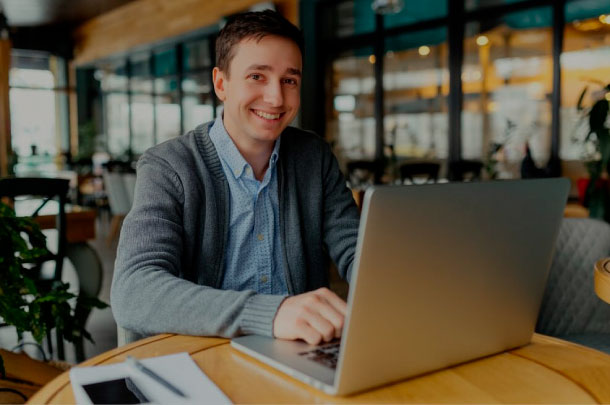 A virtual financial outsourcing services assistant works on his laptop.