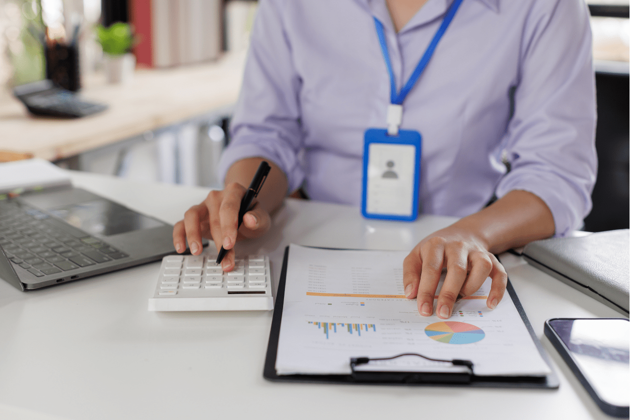 Businesswoman using calculator and pen to manage financial data at desk