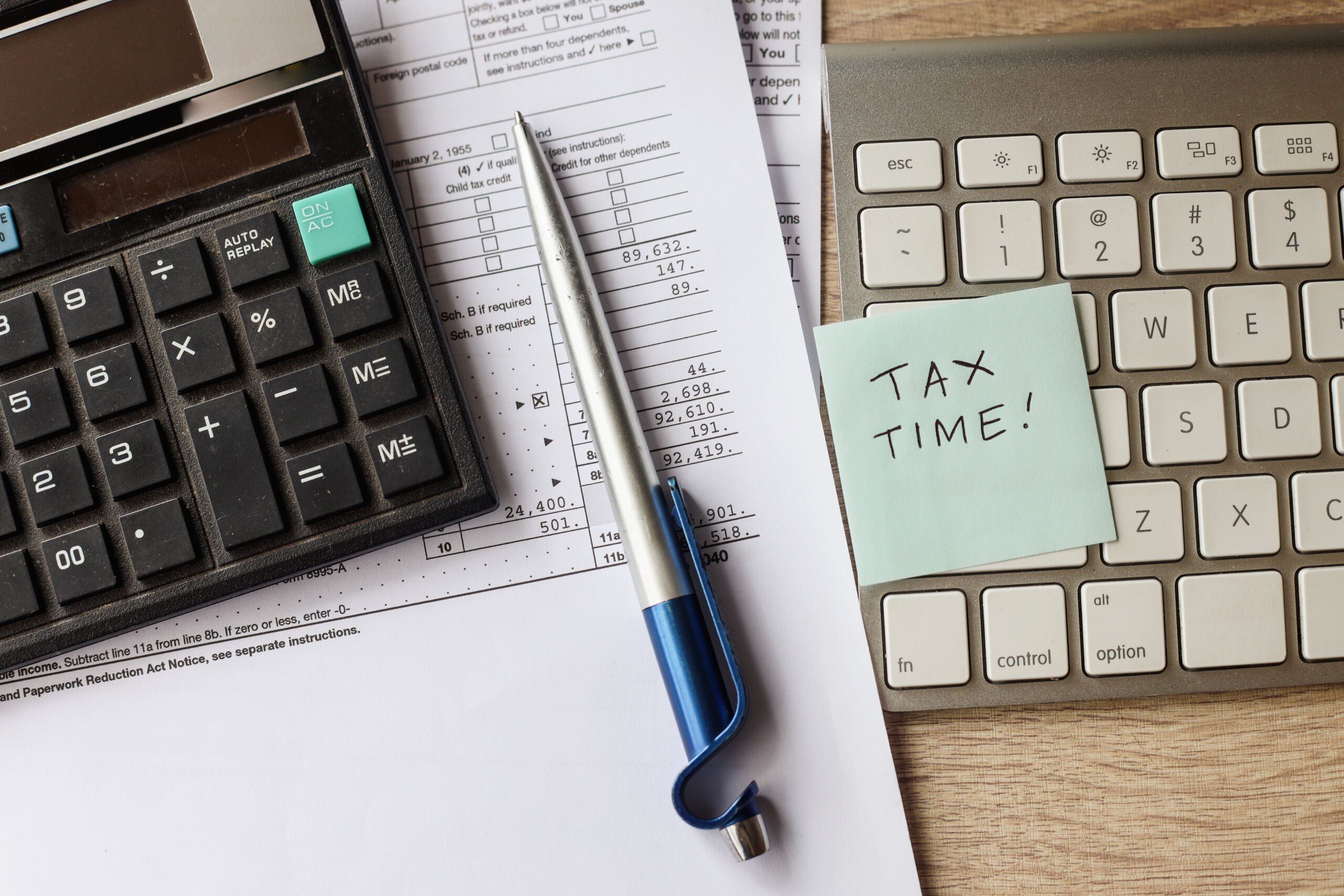 outsource tax preparation services​ with calculator, keyboard, and income tax return form