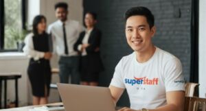 An outsourced accounting services professional is smiling while working on his laptop.